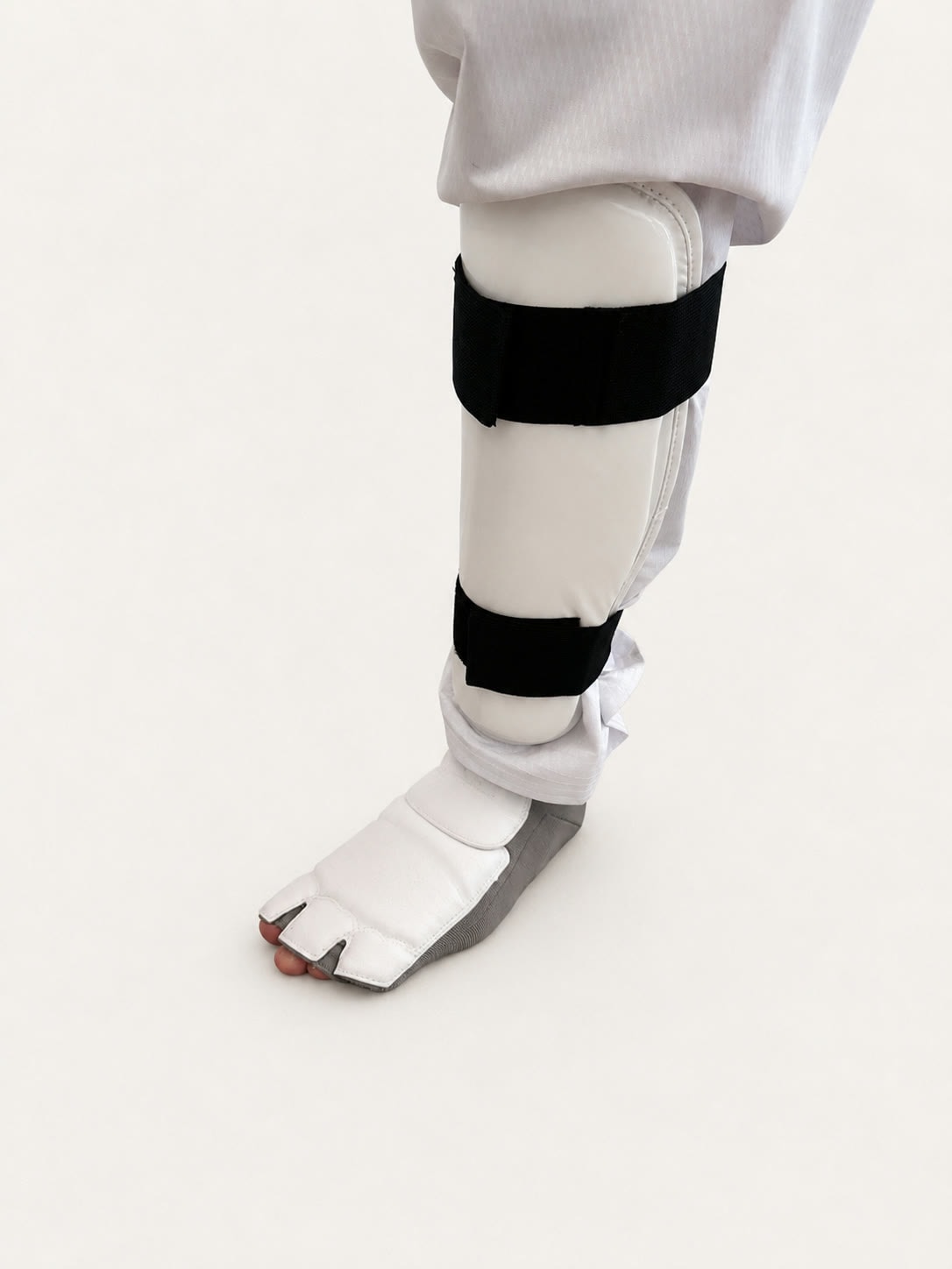 Standard taekwondo foot protector worn with a shin guard - glove construction with each toe in its own slot and a thin layer of padding across the foot